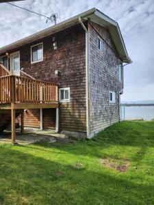 a brick house with a porch and a deck at Plainview Motel in Coos Bay