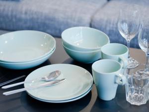 a table with white plates and cups and glasses at Sukumo -蒅- in Tokyo