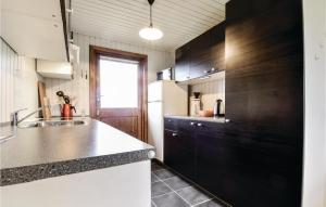 una cocina con armarios en blanco y negro y fregadero en Stunning Home In Brenderup Fyn With Wifi, en Skovs-Højrup