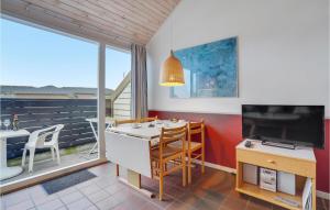 ein Wohnzimmer mit einem TV, einem Tisch und Stühlen in der Unterkunft Lejl, 302, 1, Sal in Fanø