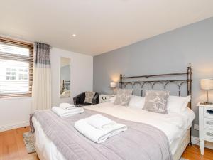 a bedroom with a large bed with towels on it at Mermaid Cottage in Whitby