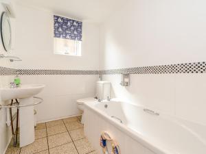 a bathroom with a tub and a sink and a toilet at Mermaid Cottage in Whitby +8 photos