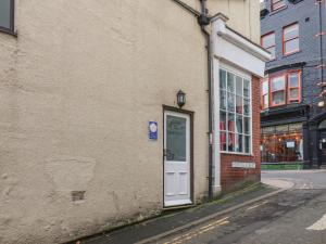 a building with a door on the side of a street at Mermaid Cottage in Whitby