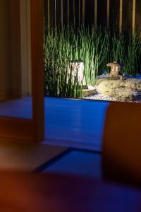 Blick auf einen Garten mit einer Bank und Gras in der Unterkunft Luck You Kyoto in Kyoto