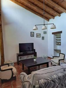 sala de estar con TV, mesa y sillas en Casona de coria en Luján de Cuyo