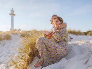 Eine Frau, die im Sand am Strand sitzt in der Unterkunft 2 person holiday home in Nex in Neksø