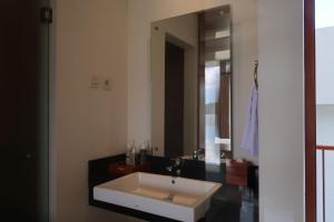 a bathroom with a sink and a large mirror at Rusa by The Lake in Baturiti