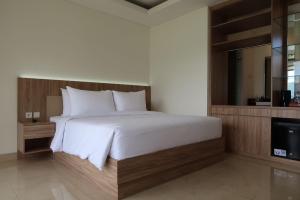 a bedroom with a large bed and a television at Rusa by The Lake in Baturiti