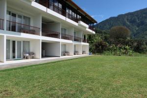 an exterior view of a building with a grass field at Rusa by The Lake in Baturiti