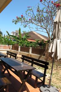 a picnic table and an umbrella next to a picnic table and an umbrella at Penang Batu Ferringhi Beach Bungalow Villa in Batu Ferringhi