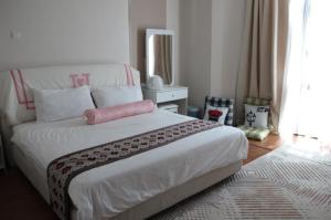 a bedroom with a bed with a pink pillow on it at Penang Batu Ferringhi Beach Bungalow Villa in Batu Ferringhi