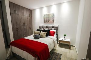 een slaapkamer met een groot bed met rode kussens bij PP Nuevo Apartamento Moderno y Central in Ibagué