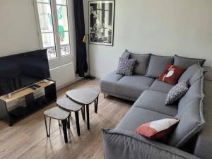 sala de estar con sofá y taburetes en Au cœur du Quartier St Vincent de Paul, Le Havre en Le Havre