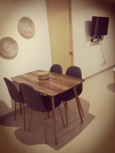 uma mesa de madeira com cadeiras e uma televisão num quarto em Moderno, ubicación estratégica. em Bucaramanga