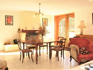 une salle à manger avec une table, des chaises et une cheminée dans l'établissement Stone house with private pool, à Villefranche-du-Périgord