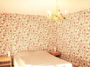- une chambre avec un mur à motifs floraux et un lit dans l'établissement Stone house with private pool, à Villefranche-du-Périgord