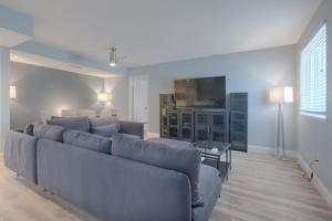 a living room with a couch and a tv at Good Times Tan Lines Oceanview Condo Pet Friendly in Jacksonville Beach