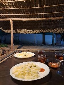 two plates of food sitting on a table at PONMUDI DALE. HOMESTAY in Kallar-Bridge