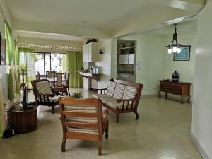 a living room with wooden chairs and a table at Casa del Vega a Little Peace of Heaven in Castries