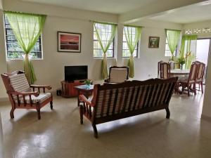 a living room with a couch and chairs and a television at Casa del Vega a Little Peace of Heaven in Castries