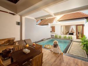 a living room with a pool in the middle of a house at Avery Le Nixsun Villas Uluwatu by Waringin Hospitality in Jimbaran