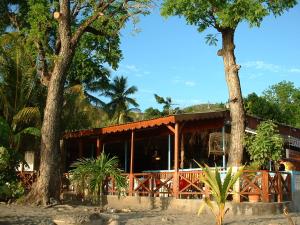 a resort building with trees in front of it at Catamaran TAO in Sainte-Anne