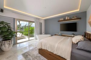 a bedroom with a bed and a tub and a television at La Amada Cancun in Cancún