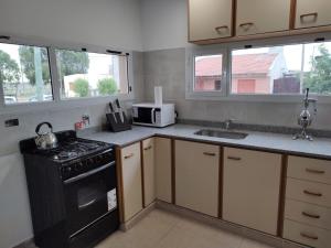 una cocina con estufa y fregadero en Los departamentos de Eva, en San Antonio Oeste 2 fotos más