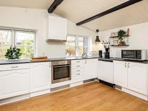 a large white kitchen with white cabinets and appliances at 8 person holiday home in Vig-By Traum in Vig +39 photos