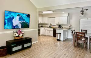 a kitchen and dining room with a large tv on the wall at Beautiful Beach house with heated pool in Jacksonville