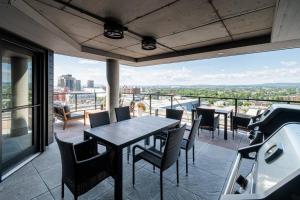 a patio with a table and chairs on a balcony at CONDO 2 CH - 500M Vieux-Québec & gym in Quebec City