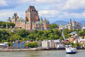 a view of a city with a boat in the water at CONDO 2 CH - 500M Vieux-Québec & gym in Quebec City