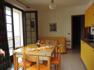 een keuken en eetkamer met een tafel met een glas wijn bij Appartement in Cassone Di Malcesine mit Garten in Malcesine