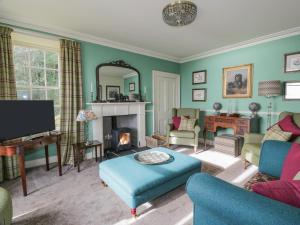 a living room filled with furniture and a fireplace at Port Donnel Cottage in Dalbeattie