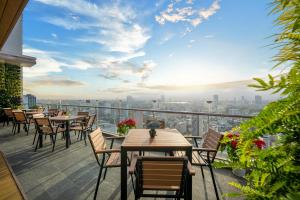 d'un balcon avec des tables et des chaises offrant une vue sur la ville. dans l'établissement Diamond Sea Hotel, à Đà Nẵng