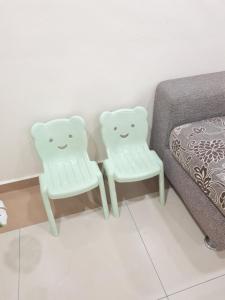 two white chairs sitting next to a bed at Air-home M9 Simpang near Aulong Econsave, 4BR, 10pax, Netflix in Taiping
