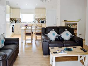 ein Wohnzimmer mit einem Sofa und einem Tisch in der Unterkunft Ash Lodge in Clatworthy
