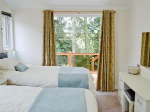 sypialnia z 2 łóżkami i dużym oknem w obiekcie Ash Lodge w mieście Clatworthy