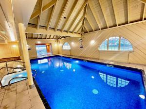 a large swimming pool in a building with a large at Loch Linnhe Waterfront Lodges with Hot Tubs in Glencoe