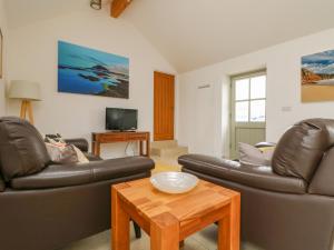 a living room with two leather couches and a coffee table at Pen Tewan in Penzance