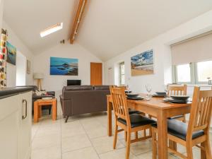 een eetkamer en een woonkamer met een tafel en stoelen bij Pen Tewan in Penzance