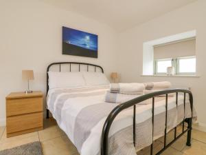 a bedroom with a bed and a nightstand with a bed at Pen Tewan in Penzance