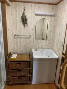 uma casa de banho com um lavatório e um espelho em Guesthouse Shin em Omihachiman