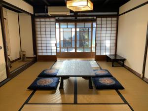 a room with a table and mats on the floor at Guesthouse Shin in Omihachiman