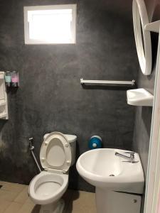 La salle de bains est pourvue de toilettes et d'un lavabo. dans l'établissement Green Happy Homestay, à Phatthalung