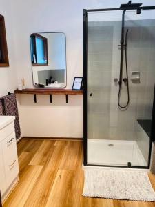 a bathroom with a shower with a mirror and a sink at Riverlin Estate in Warburton