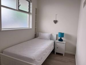 um pequeno quarto com uma cama e uma janela em Modern Beach Oasis in Elwood Village em Melbourne
