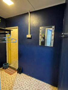 a bathroom with a blue wall and a mirror at Vintage Guesthouse in Tanah Rata