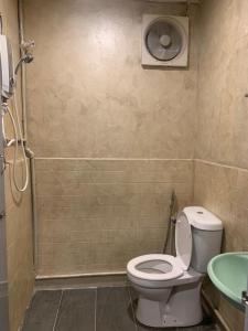 a bathroom with a toilet and a sink and a shower at Vintage Guesthouse in Tanah Rata
