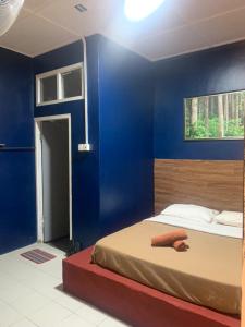 a bedroom with a blue wall and a bed at Vintage Guesthouse in Tanah Rata